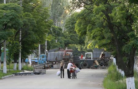 Local residents pass a checkpoint controlled by pro-Russia separatists in the eastern Ukranian city of Slaviansk June 16, 2014. REUTERS/Shamil Zhumatov