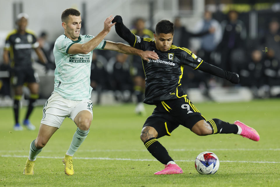 Columbus Crew's Cucho Hernandez, right, shoots past Atlanta United's Brooks Lennon, left, during the second half of an MLS playoff soccer match Sunday, Nov. 12, 2023, in Columbus, Ohio. (AP Photo/Jay LaPrete)