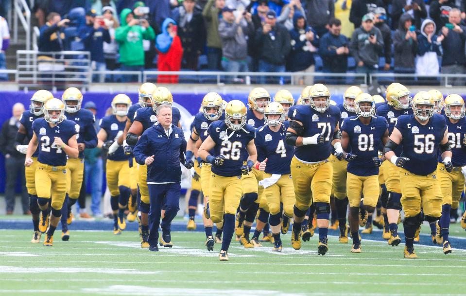 Fighting Irish head coach Brian Kelly runs onto the field with the team before the 2018 Citrus Bowl.