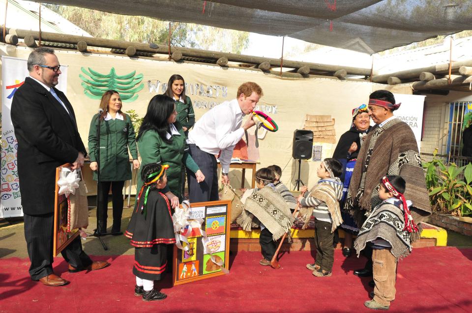 Britain's Prince Harry blows a plastic "trutruca" during a visit to Integra Foundation, a daycare center for at-risk children, in Santiago