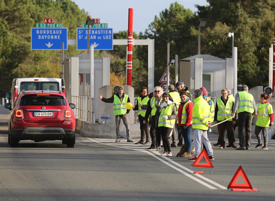 Demonstrators wearing yellow vests protest at the toll gates of a motorway, in Biarritz, southwestern France, Monday, Dec. 10, 2018. French President Emmanuel Macron will be speaking to his nation at last Monday, after increasingly violent, radicalized protests against his leadership have shaken the country and scarred its beloved capital. His long silence has aggravated that anger and many protesters are hoping only to hear one thing from Macron: “I quit.” (AP Photo/Bob Edme)
