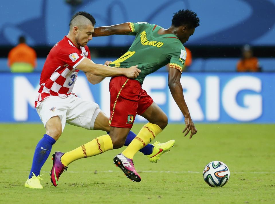 Croatia's Danijel Pranjic (L) fights for the ball with Cameroon's Benjamin Moukandjo during their 2014 World Cup Group A soccer match at the Amazonia arena in Manaus June 18, 2014. REUTERS/Murad Sezer (BRAZIL - Tags: SOCCER SPORT WORLD CUP)