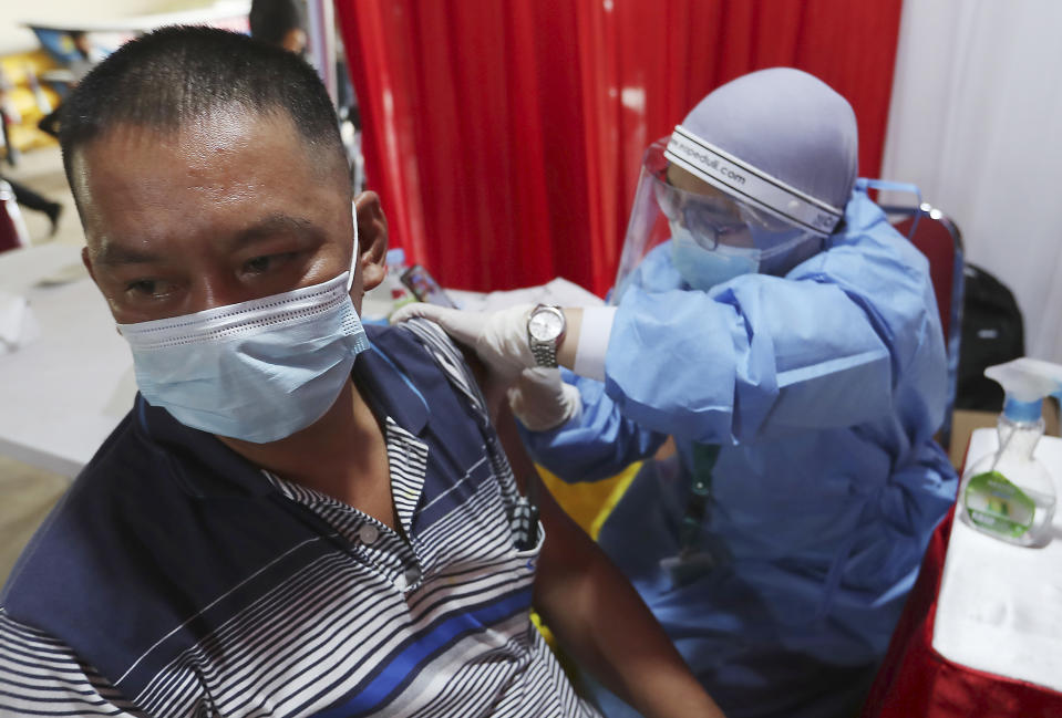 A man receive shots of the AstraZeneca vaccine during a vaccination campaign in Bekasi on the outskirts of Jakarta, Indonesia, Thursday, June 17, 2021. (AP Photo/Achmad Ibrahim)