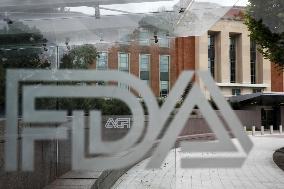 FILE - This Aug. 2, 2018, file photo shows the U.S. Food and Drug Administration building behind FDA logos at a bus stop on the agency's campus in Silver Spring, Md. On Thursday, Dec. 12, 2019, U.S. health regulators said they approved the drug Vyondys 53 for a debilitating form of muscular dystrophy, a surprise decision after the medication was rejected for safety concerns just four months earlier. (AP Photo/Jacquelyn Martin, File)
