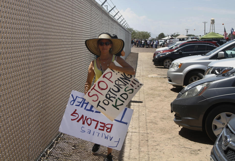 A grandmother protesting the treatment of children in Border Patrol custody walks back to her car by a fence at a holding center in Clint, Texas, July 1, 2019. Yvonne Nieves, in her 50s, says she has a 2-year-old granddaughter. "I just couldn't bear the fact that there would actually be little kids out here not knowing where their parents are, not having anyone to take care of them," she said. (AP Photo/Cedar Attanasio)