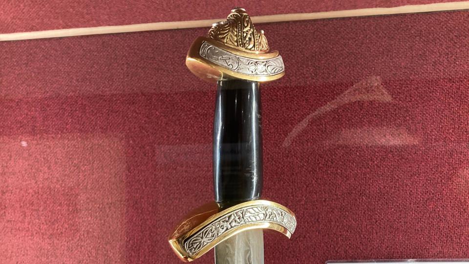 A replica of an old sword, with golden decoration on the handle