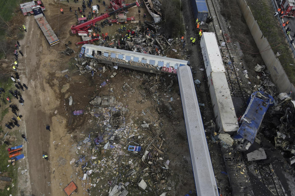 Debris of trains lie on the rail lines after a collision in Tempe, about 376 kilometres (235 miles) north of Athens, near Larissa city, Greece, Wednesday, March 1, 2023. A passenger train carrying hundreds of people, including many university students returning home from holiday, collided at high speed before midnight Tuesday with an oncoming freight train. (AP Photo/Giannis Papanikos)