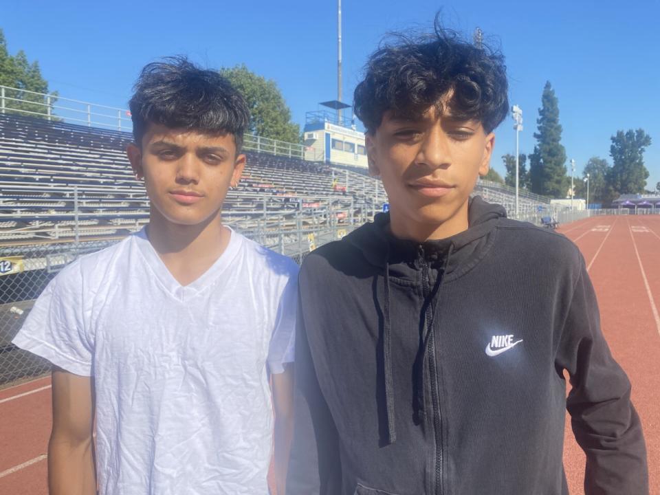 Adrian Diaz and Steven Ramos near bleachers outdoors.