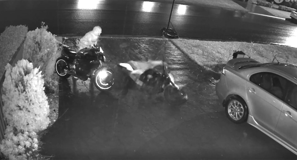 Two hooded figures are seen on a CCTV still attempting to steal a two motorbikes. 
