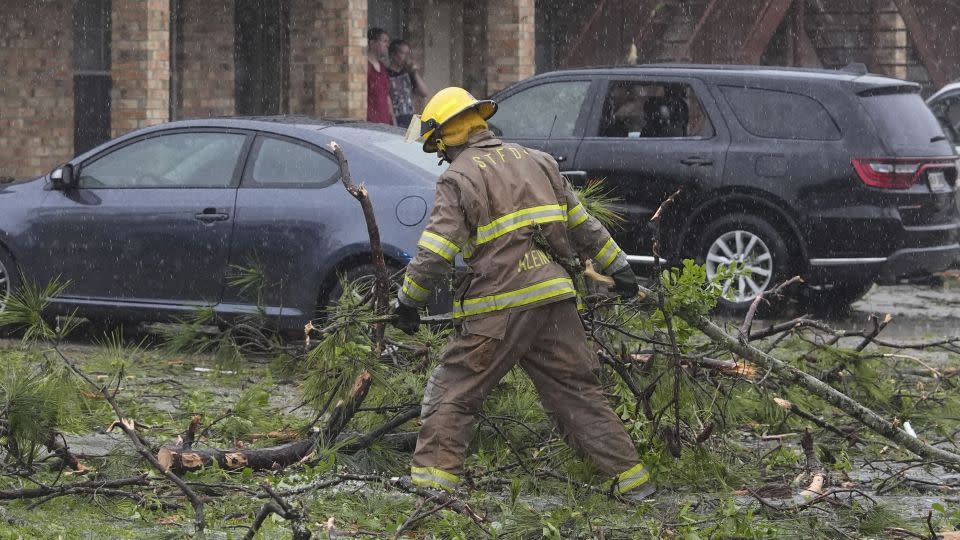 A firefighter clears debris left in the aftermath of storms in Slidell, Louisiana. - Gerald Herbert/AP