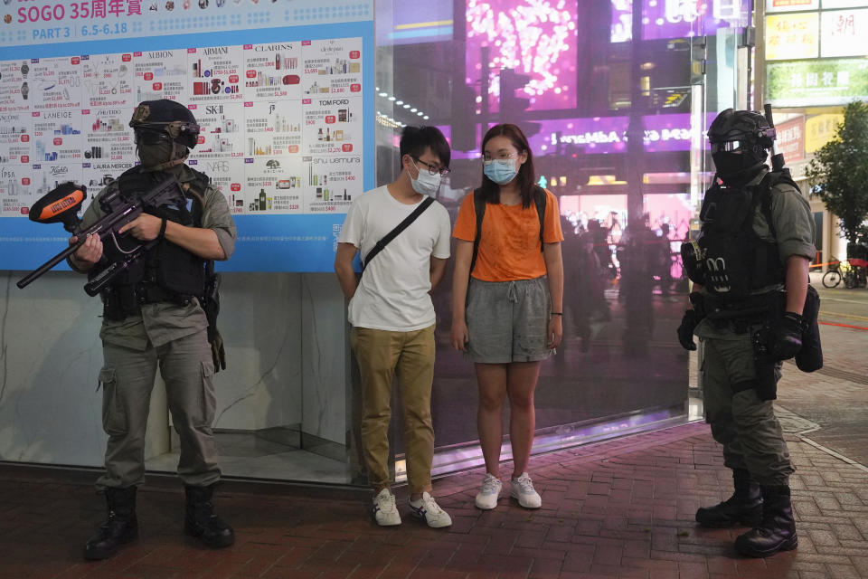 Hong Kong Riot police checking protesters on street during a protest during a protest in Causeway Bay, Hong Kong, Friday, June 12, 2020. Protesters in Hong Kong got its government to withdraw extradition legislation last year, but now they're getting a more dreaded national security law and the message from Beijing is that protest is futile. (AP Photo/Vincent Yu)