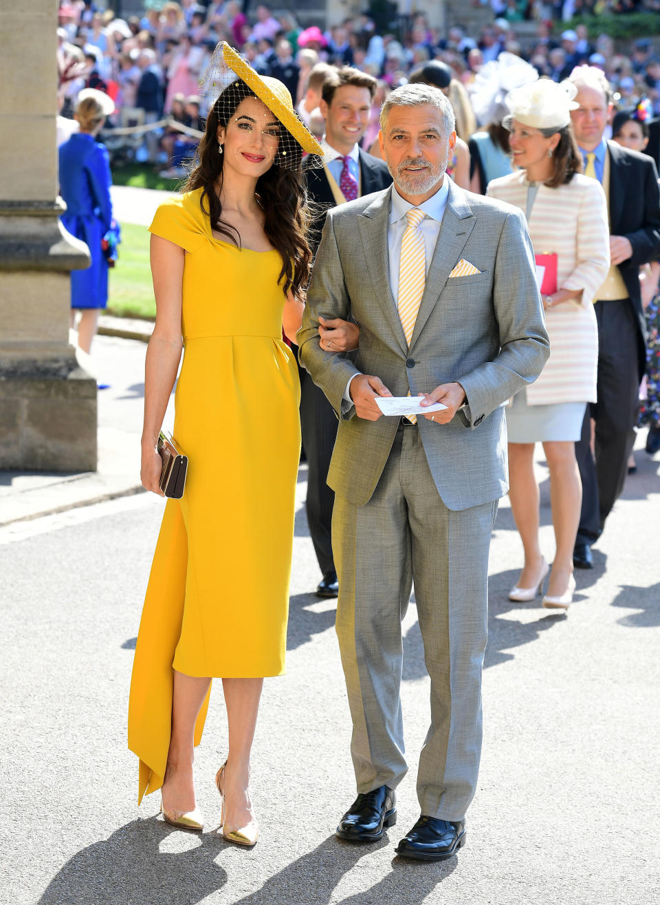 Amal Clooney dejó de lado la superstición durante el enlace del príncipe Harry y Meghan Markle, celebrado en 2018, y sorprendió con un vestido amarillo de Stella McCartney. El tocado de Stephen Jones y los zapatos de Gianvito Rossi fueron los complementos perfectos. (Foto: Ian West / Getty Images)