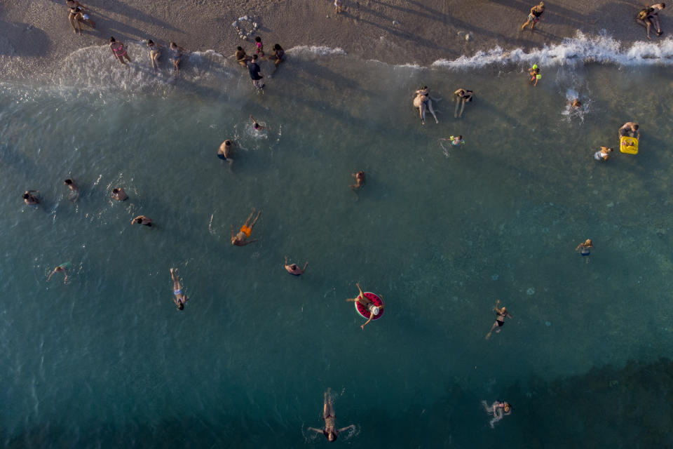 Holidaymakers enjoy the weather on a beach, in Dubrovnik, Croatia, Friday, Aug. 13, 2021. Summer tourism has exceeded even the most optimistic expectations in Croatia this year. Beaches along the country's Adriatic Sea coastline are swarming with people. Guided tours are fully booked, restaurants are packed and sailboats were chartered well in advance. (AP Photo/Darko Bandic)