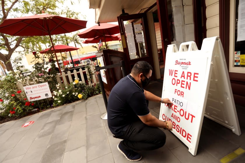 LOS ANGELES, CA - JULY 01, 2020 - - Martin Tario, who co-owns Dupar's Restaurant with his wife Frances, replaces "dine-in" with "patio" at the establishment which is still receiving customers for patio dining and take-out service at the Original Farmers Market in the Fairfax District in Los Angeles on July 1, 2020. California Governor Gavin Newsom ordered indoor restaurants closed effective immediately on July 1, 2020. (Genaro Molina / Los Angeles Times)