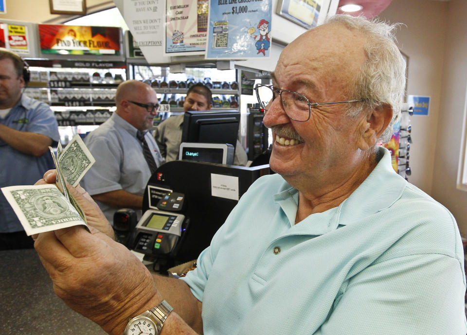Wes Prinzen, of Fountain Hills, Ariz., smiles as he takes away his modest $4 winnings, at a 4 Sons Food Store where one of the winning tickets in the $579.9 million Powerball jackpot was purchased, Nov. 29, 2012, in Fountain Hills, Ariz. (AP Photo/Ross D. Franklin)
