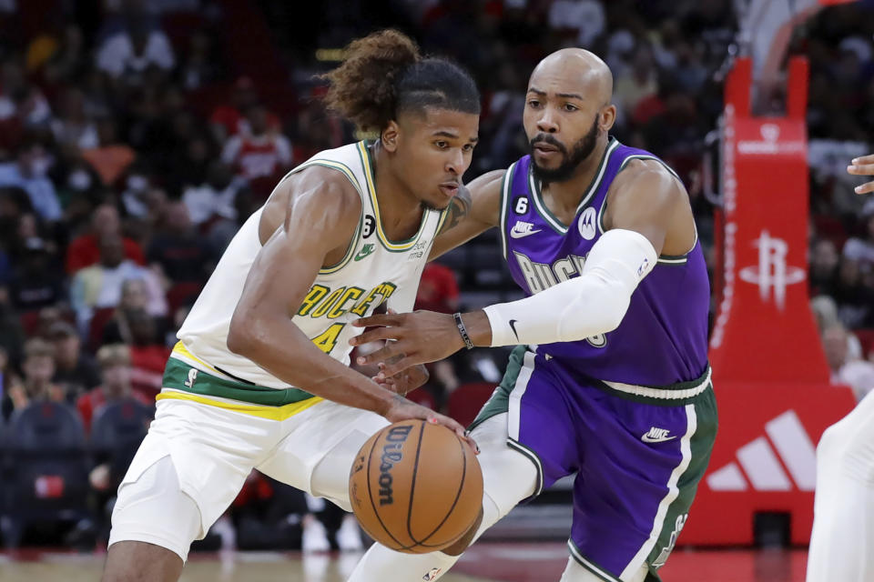 Houston Rockets guard Jalen Green, left, drives past Milwaukee Bucks guard Jevon Carter, right, during the first half of an NBA basketball game Sunday, Dec. 11, 2022, in Houston. (AP Photo/Michael Wyke)