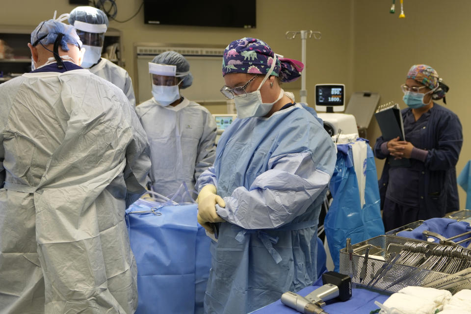 LPN scrub nurse Ashton Conrad, center, and other members of the organ recovery team pause for a moment of silence to honor the organ donor before procurement surgery begins June 15, 2023, in Jackson, Tenn. (AP Photo/Mark Humphrey)