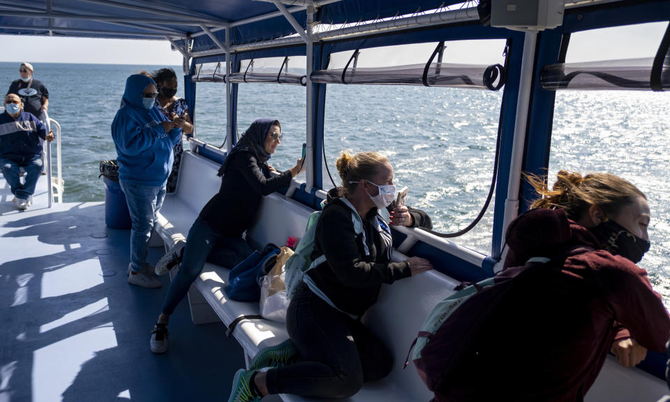 Participants during a whale spotting cruise aboard the vessel American Princess anticipate another surfacing of a Humpback whale designated "Whale 0140," identified through patterns on the whale's fluke, after it was briefly seen during a cruise offered by Gotham Whale, as the Humpback is spotted off the northern New Jersey coast line Wednesday, Sept. 23, 2020. The increased sighting of whales off New York City isn't necessarily evidence that the total whale population is growing, said Danielle Brown, the lead humpback whale researcher with Gotham Whale and a doctoral student at Rutgers University. (AP Photo/Craig Ruttle)