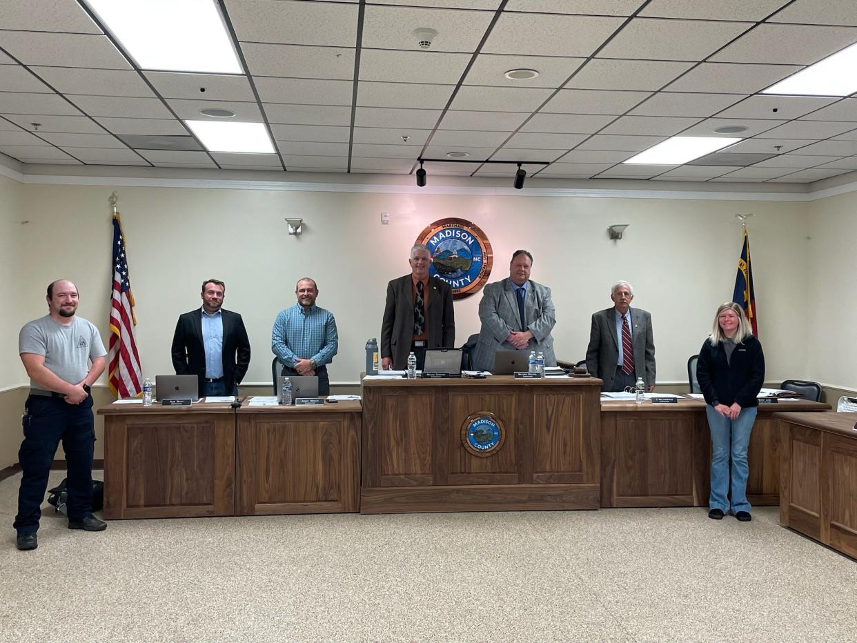 Dillon Cantrell, left, and Chelsea Lewis, stand before the Madison County Board of Commissioners after the commissioners adopted a resolution honoring 911 telecommunicators April 9.