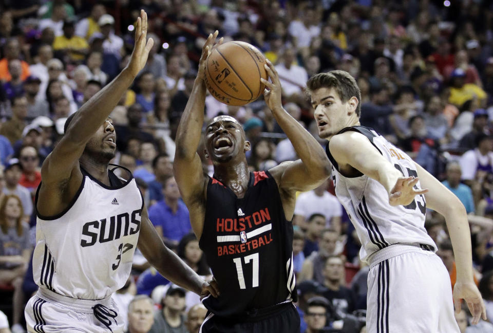 Isaiah Taylor, center, drives between a pair of Suns during a summer-league game. (AP)