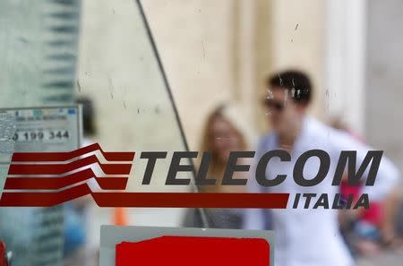 People walk past a Telecom Italia phone booth in Rome August 28, 2014. REUTERS/Max Rossi