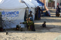 Displaced people from heavy monsoon flooding take refuge as they prepare tea at a temporary tent housing camp organized by the UN Refugee Agency (UNHCR), in Sukkur, Pakistan, Saturday, Sept. 10, 2022. Months of heavy monsoon rains and flooding have killed over a 1000 people and affected 3.3 million in this South Asian nation while half a million people have become homeless. (AP Photo/Fareed Khan)