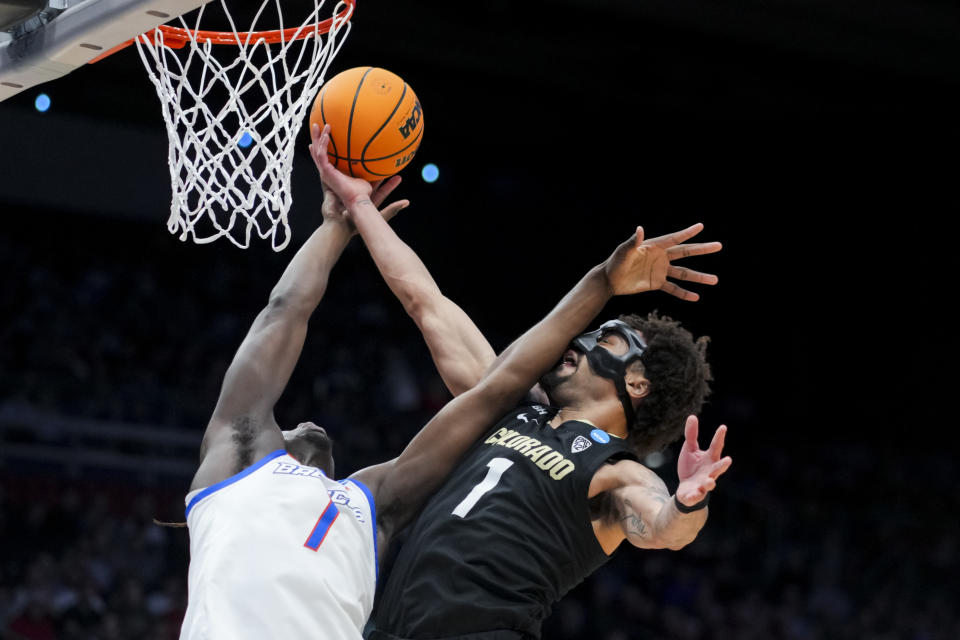 Boise State forward O'Mar Stanley, left, battles for a rebound against Colorado guard J'Vonne Hadley during the first half of a First Four game in the NCAA men's college basketball tournament Wednesday, March 20, 2024, in Dayton, Ohio. (AP Photo/Aaron Doster)