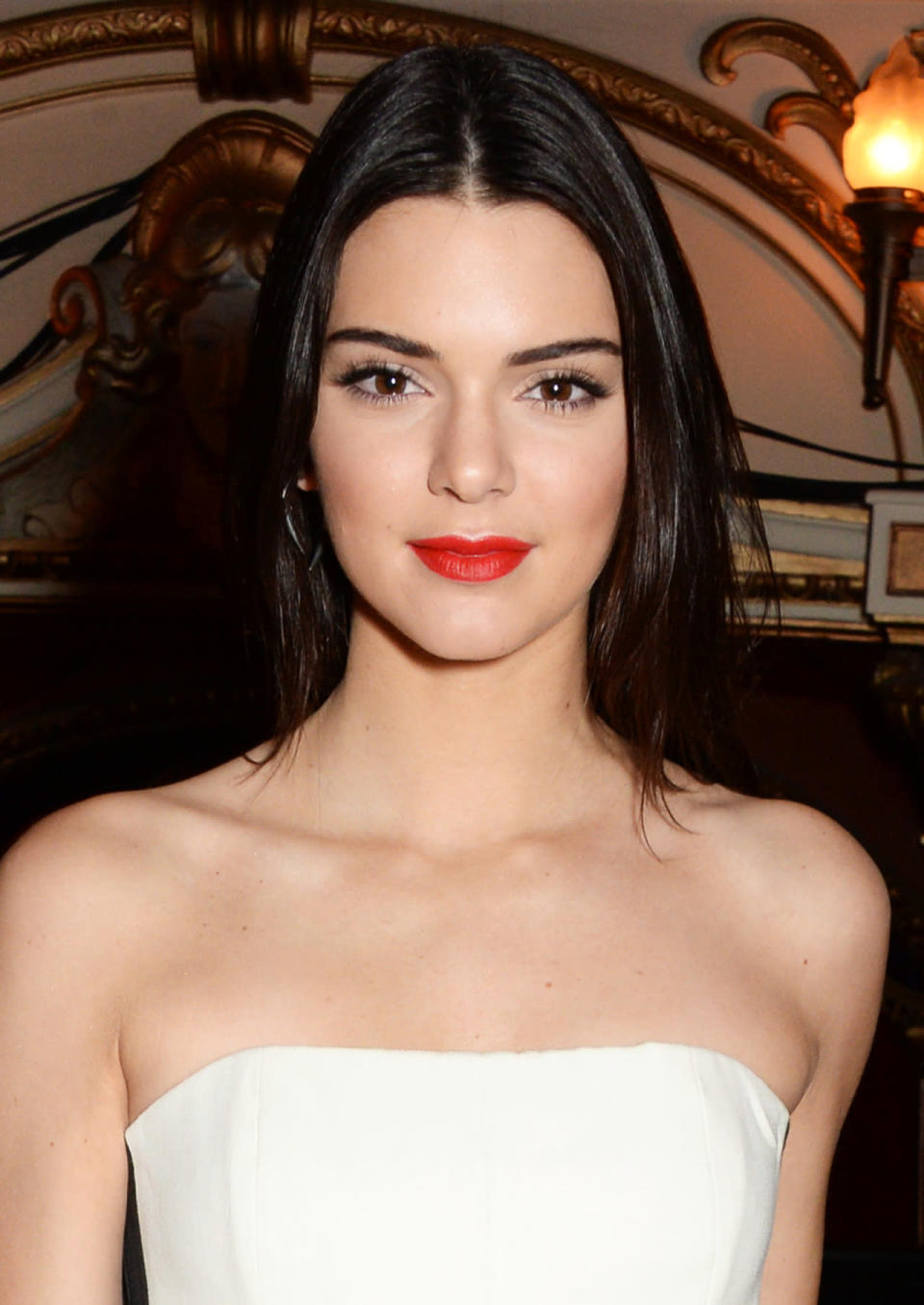 <p>At a reception for the British Fashion Awards in London, Jenner’s simple nighttime look consisted of orange-red lipstick, light bronzer, and straightened hair. <i>(Photo: Getty Images)</i></p>