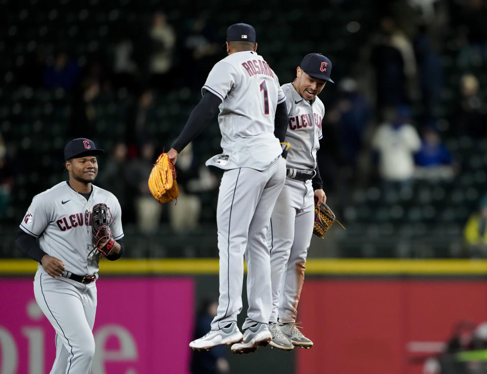 Cleveland Guardians shortstop Amed Rosario (1) jumps up to greet left fielder Steven Kwan, right, as they celebrate the team's 9-4 win over the Seattle Mariners in a baseball game Friday, March 31, 2023, in Seattle. (AP Photo/Lindsey Wasson)