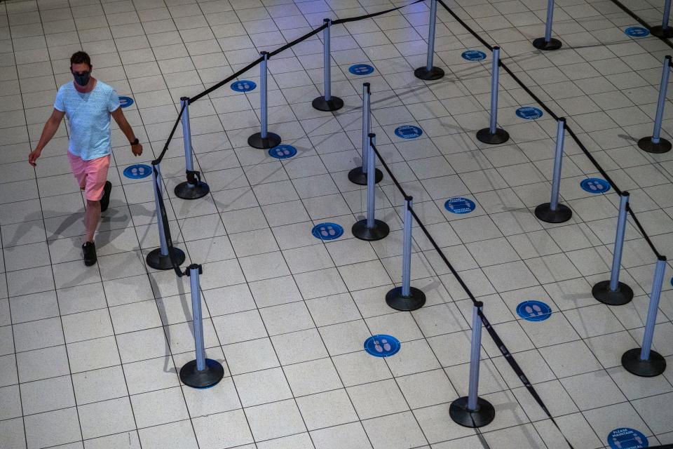 A man walks through a deserted part of Johannesburg's OR Tambo's airport Monday Nov. 29, 2021. The World Health Organization urged countries around the world not to impose flight bans on southern African nations due to concern over the new omicron variant.