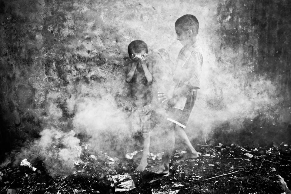 Two homeless street children were playing in the smoke created from burnt straws at Chittagong, Bangladesh. Suddenly dense smoke covered them and they were trying to protect themselves and escape. (Kazi Riasat Alve, Bangladesh, Shortlist, Split Second, Open Competition 2013 Sony World Photography Awards) <br> <br> <a href="http://worldphoto.org/about-the-sony-world-photography-awards/" rel="nofollow noopener" target="_blank" data-ylk="slk:Click here to see the full shortlist at World Photography Organisation;elm:context_link;itc:0;sec:content-canvas" class="link ">Click here to see the full shortlist at World Photography Organisation</a>