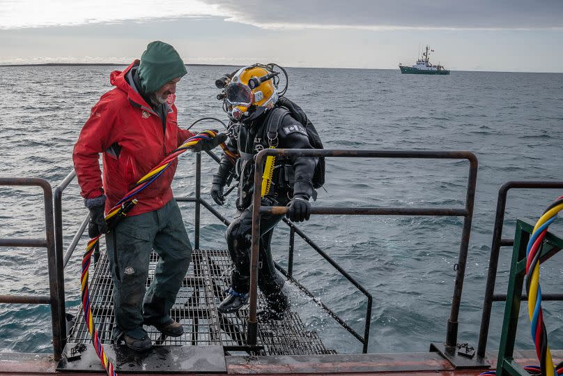 Underwater archaeology technician Todd Stakenvicius returns to a support barge after a dive on HMS Erebus, with the RV David Thompson in the background, 6 September, 2023.