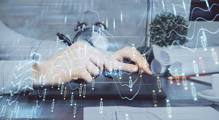 Tech stocks: Double exposure of man's hands holding and using a phone and financial graph drawing.