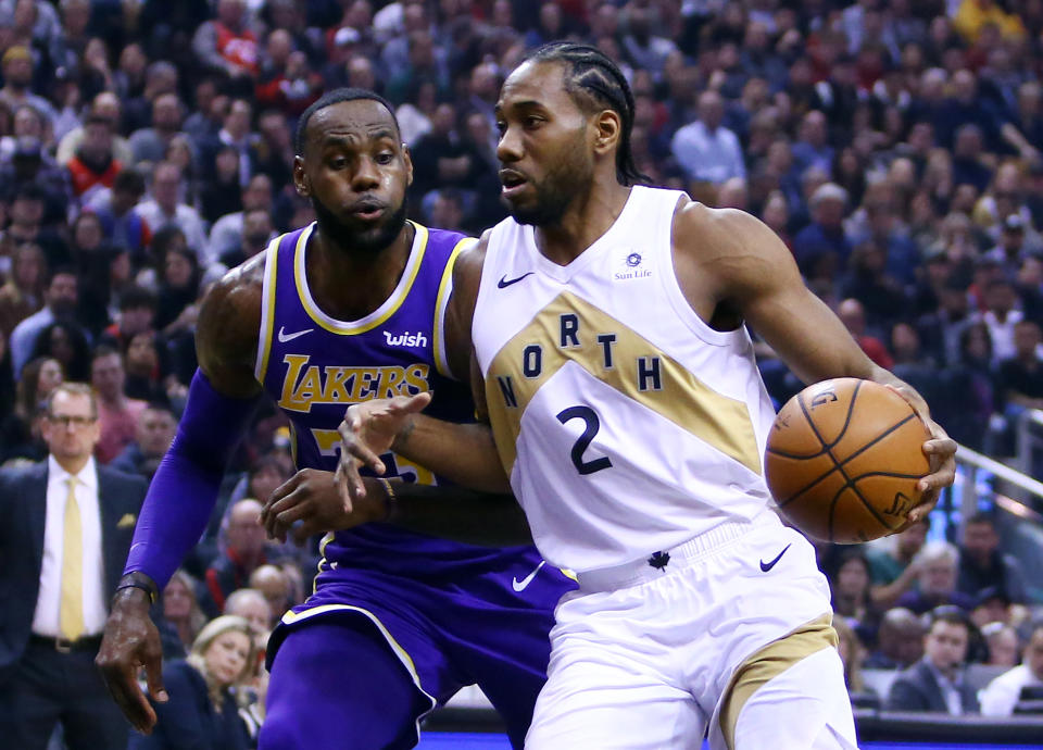 TORONTO, ON - MARCH 14:  Kawhi Leonard #2 of the Toronto Raptors dribbles the ball as LeBron James #23 of the Los Angeles Lakers defends during the first half of an NBA game at Scotiabank Arena on March 14, 2019 in Toronto, Canada.  NOTE TO USER: User expressly acknowledges and agrees that, by downloading and or using this photograph, User is consenting to the terms and conditions of the Getty Images License Agreement.  (Photo by Vaughn Ridley/Getty Images)