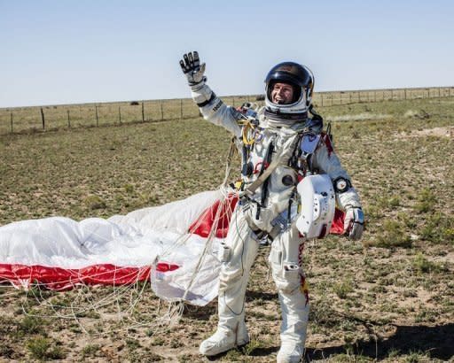 Austrian daredevil Felix Baumgartner celebrates after successfully completing his jump from the edge of space. He was in freefall for four minutes and 20 seconds before opening his red and white parachute and floating down to the desert in New Mexico. Image provided by www.redbullcontentpool.com