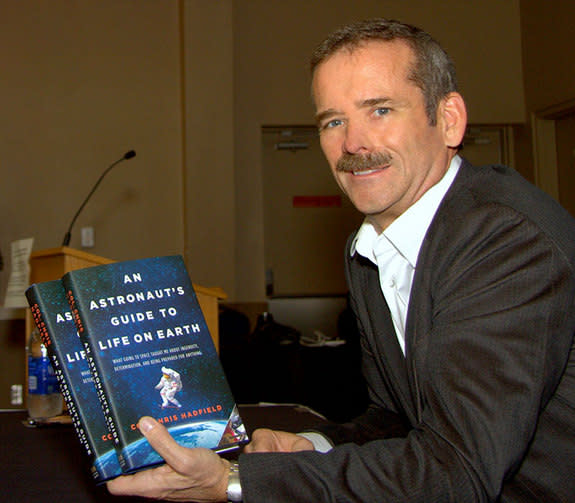 Canadian astronaut Chris Hadfield holds up copies of his book, "An Astronaut's Guide to Life on Earth."