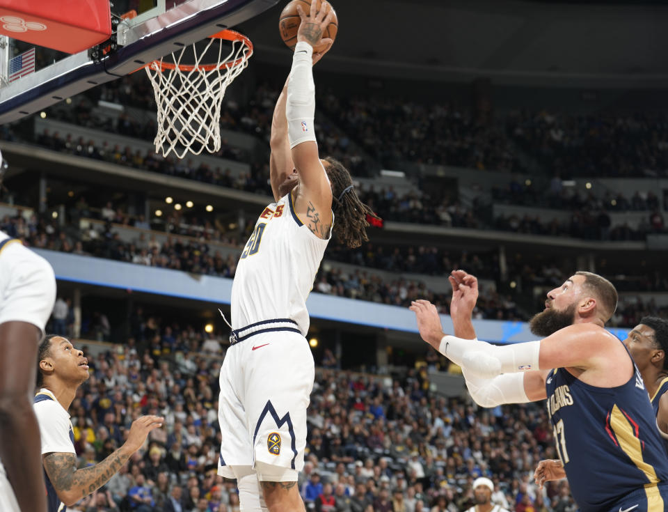 Denver Nuggets forward Aaron Gordon, center, goes up to dunk past New Orleans Pelicans center Jonas Valanciunas, front right, in the first half of an NBA basketball game Monday, Nov. 6, 2023, in Denver. (AP Photo/David Zalubowski)