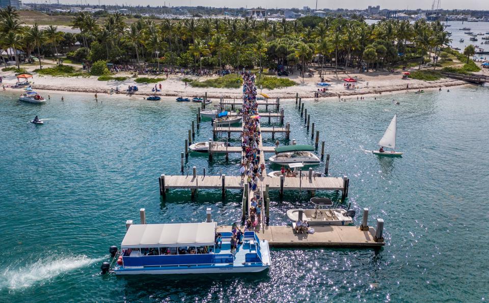 People line on the dock of Peanut Island to catch a ride on a water taxi during the Memorial Day weekend on Sunday, May 26, 2019.