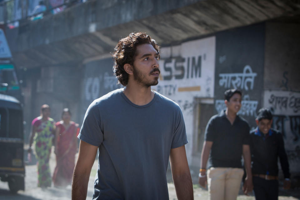 Dev Patel looking around.