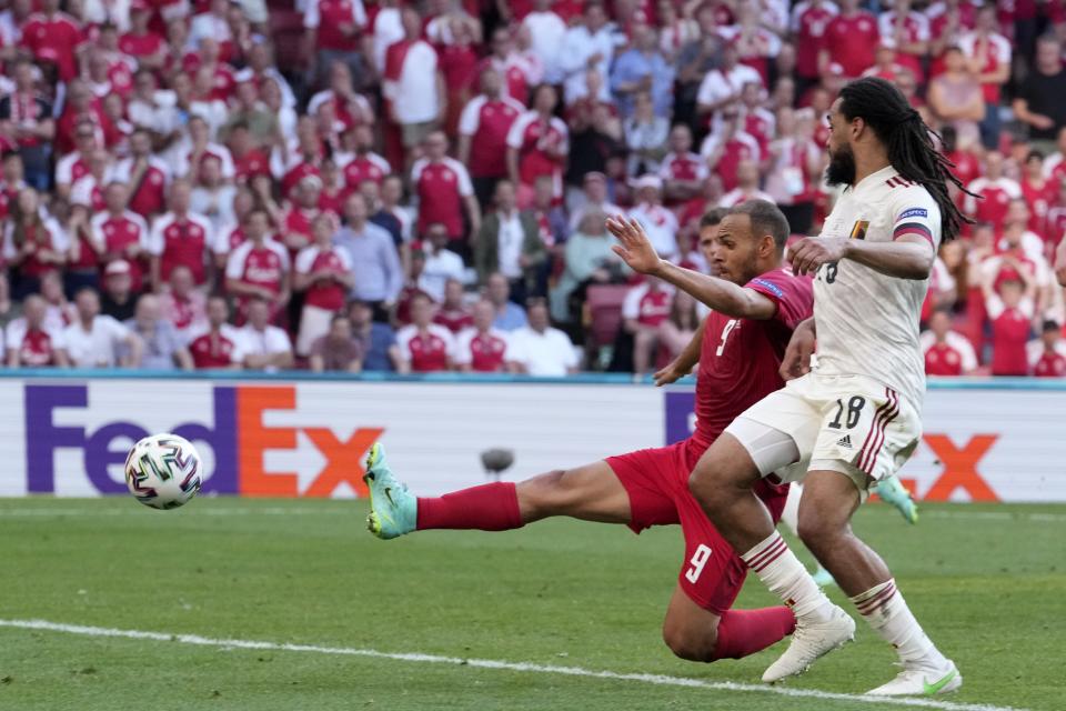 Denmark's Martin Braithwaite, background, makes an attempt to score as Belgium's Jason Denayer looks on during the Euro 2020 soccer championship group B match between Denmark and Belgium at Parken stadium in Copenhagen, Denmark, Thursday, June 17, 2021. (AP Photo/Martin Meissner, Pool)