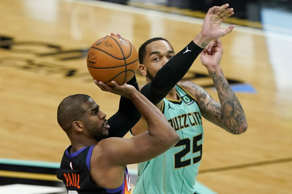 Phoenix Suns guard Chris Paul scores past Charlotte Hornets forward P.J. Washington during the second half of an NBA basketball game on Sunday, March 28, 2021, in Charlotte, N.C. (AP Photo/Chris Carlson)