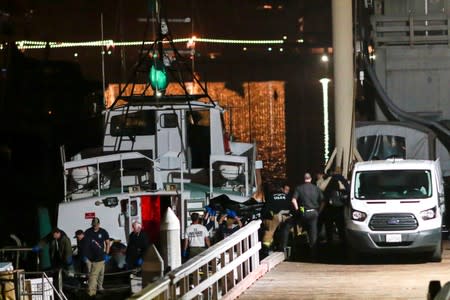 Rescue personnel return to shore with the victims of a pre-dawn fire that sank a commercial diving boat off the coast of Santa Barbara, California