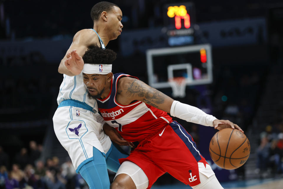 Washington Wizards guard Jordan Goodwin, right, drives against Charlotte Hornets guard Bryce McGowens during the first half of an NBA basketball game in Charlotte, N.C., Friday, Dec. 2, 2022. (AP Photo/Nell Redmond)