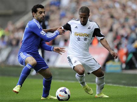Swansea City's Wayne Routledge is challenged by Chelsea's Mohamed Salah (L) during their English Premier League soccer match at the Liberty Stadium in Swansea, Wales, April 13, 2014. REUTERS/Rebecca Naden