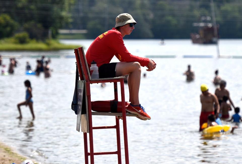 An City of Ottawa lifeguard keeps an eye on swimmers at Mooney's Bay Beach on Sunday, Aug. 16, the last day of the 2015 supervised beach season and the first day of a five-day heat wave that saw temperatures hovering around 30 C, feeling like 40 with the humidity.