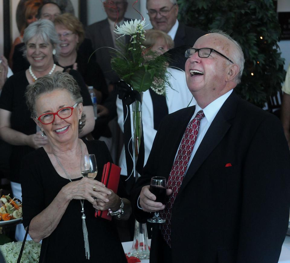 Monroe County Community College President Emeritus David Nixon (right) and his wife, Judy, enjoy the comments made during a retirement ceremony in his honor in 2013 the La-Z-Boy Center.