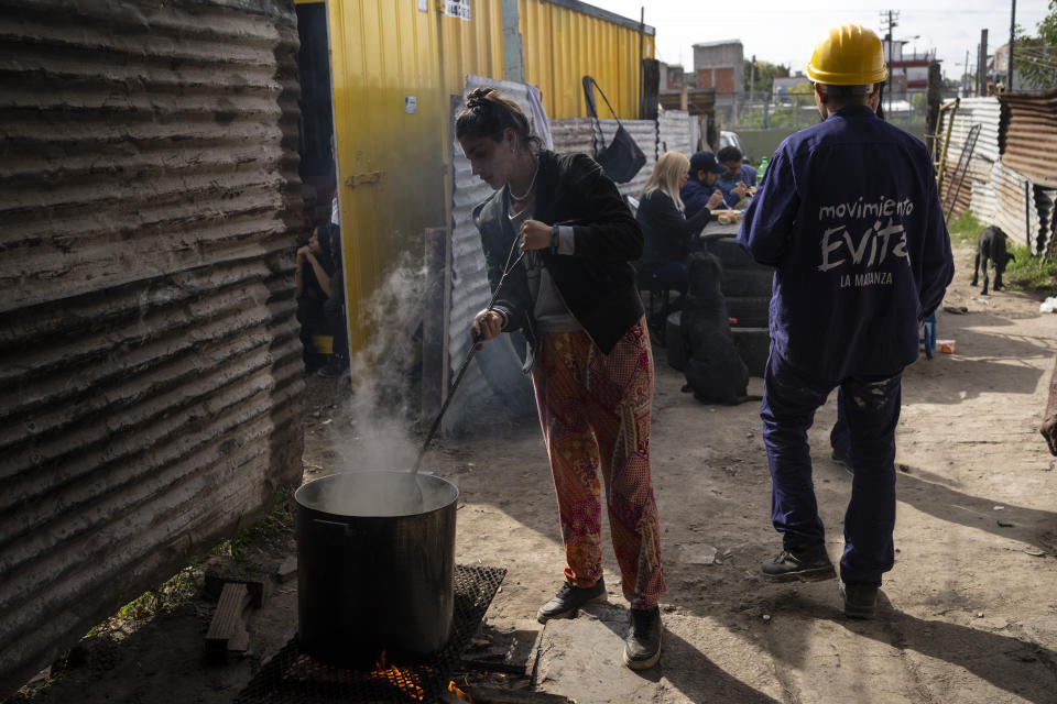 A member of the Movimiento Evita social organization stirs a cauldron of pasta at a soup kitchen that feeds their workers and residents in the Puerta de Hierro neighborhood in La Matanza district of Buenos Aires, Argentina, Wednesday, May 11, 2022. Social organizations in Argentina do not simply provide food, they also have strong ties to political leaders which facilitates receiving subsidies and access to work programs. (AP Photo/Rodrigo Abd)