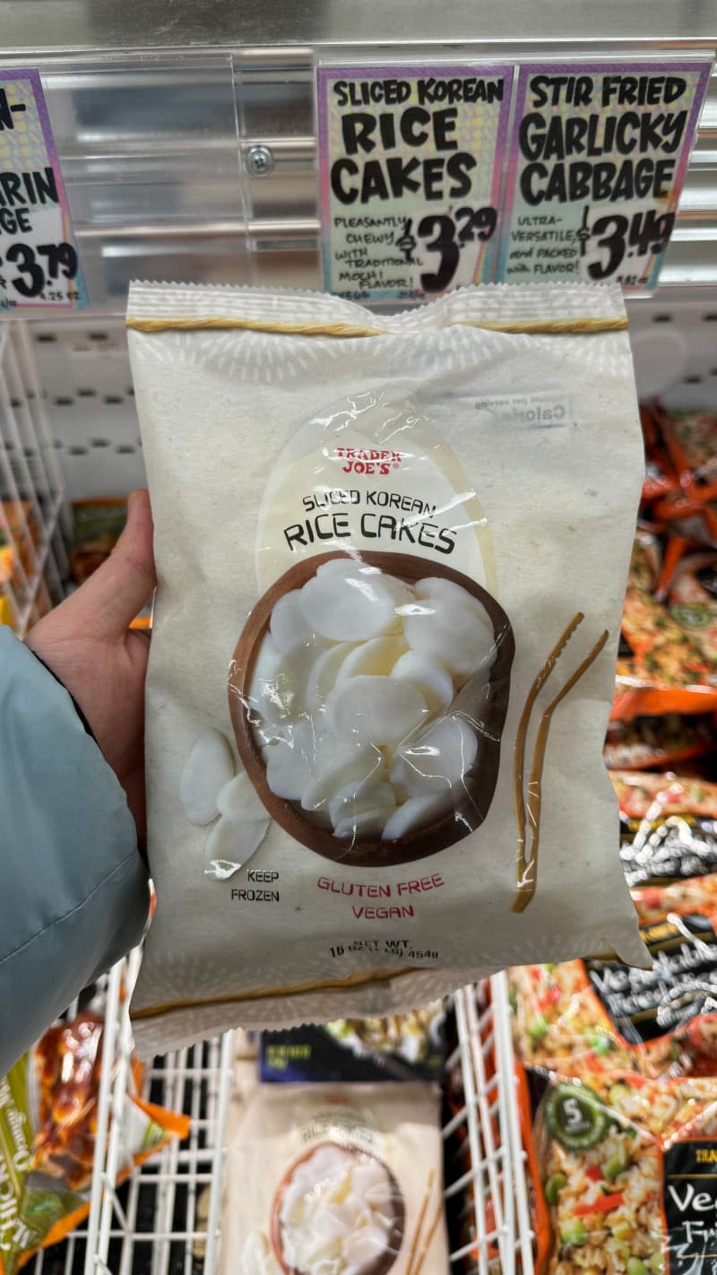 Someone holding Trader Joe's Korean rice cakes.