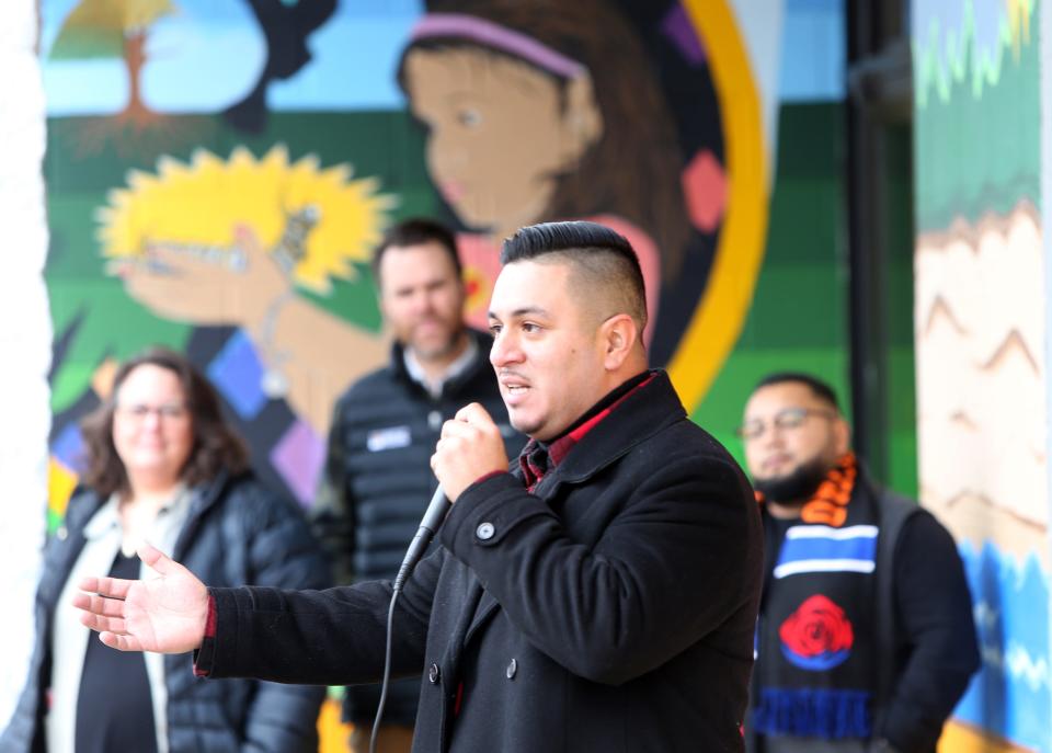 Artist Freddy Rodriguez speaks about his mural on the La Casa de Amistad building, 3423 S. Michigan St., South Bend, with the first panel in the background at the dedication on Dec. 12, 2022.