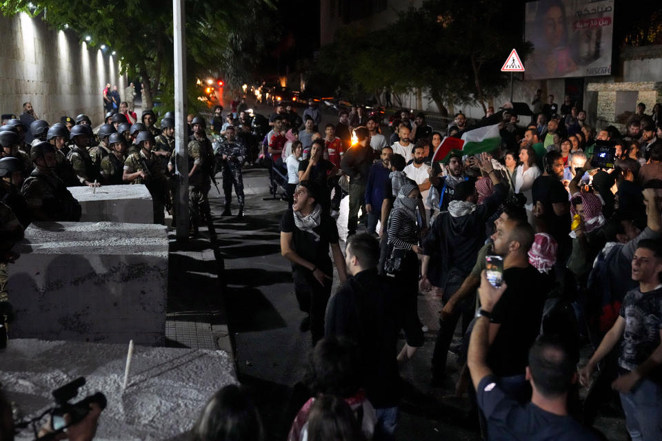 Demonstrators throw stones towards the French embassy during a protest in solidarity with the Palestinian people in Gaza, in Beirut, Lebanon, Tuesday, Oct. 17, 2023. Groups of protesters roamed the city on motorcycles and gathered outside the French embassy, and the headquarters of the U.N. Economic and Social Commission for Western Asia. They were unable to reach the heavily fortified U.S. embassy compound in the hills north of Beirut. (AP Photo/Bilal Hussein)